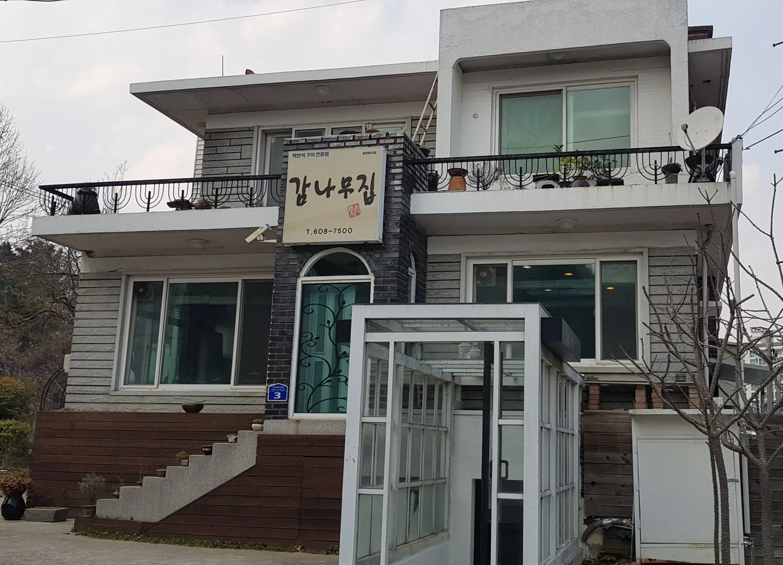 2층 흰 집, 검은 벽돌 기둥에 감나무집 간판